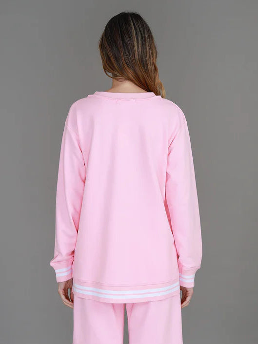 Person wearing a pink outfit against a gray background