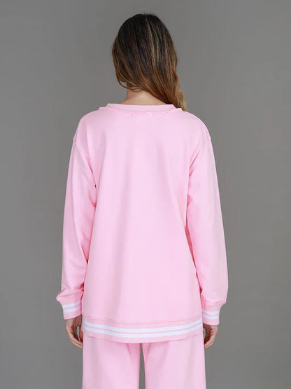 Person wearing a pink outfit against a gray background
