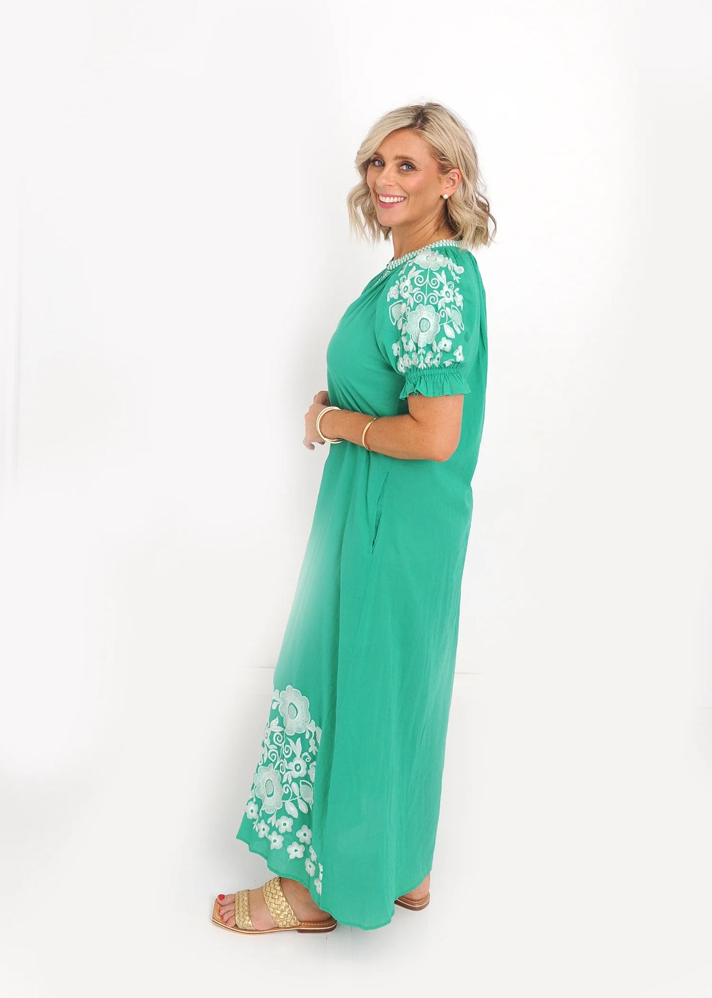 White floral embroidery detail on puff sleeve of green midi dress