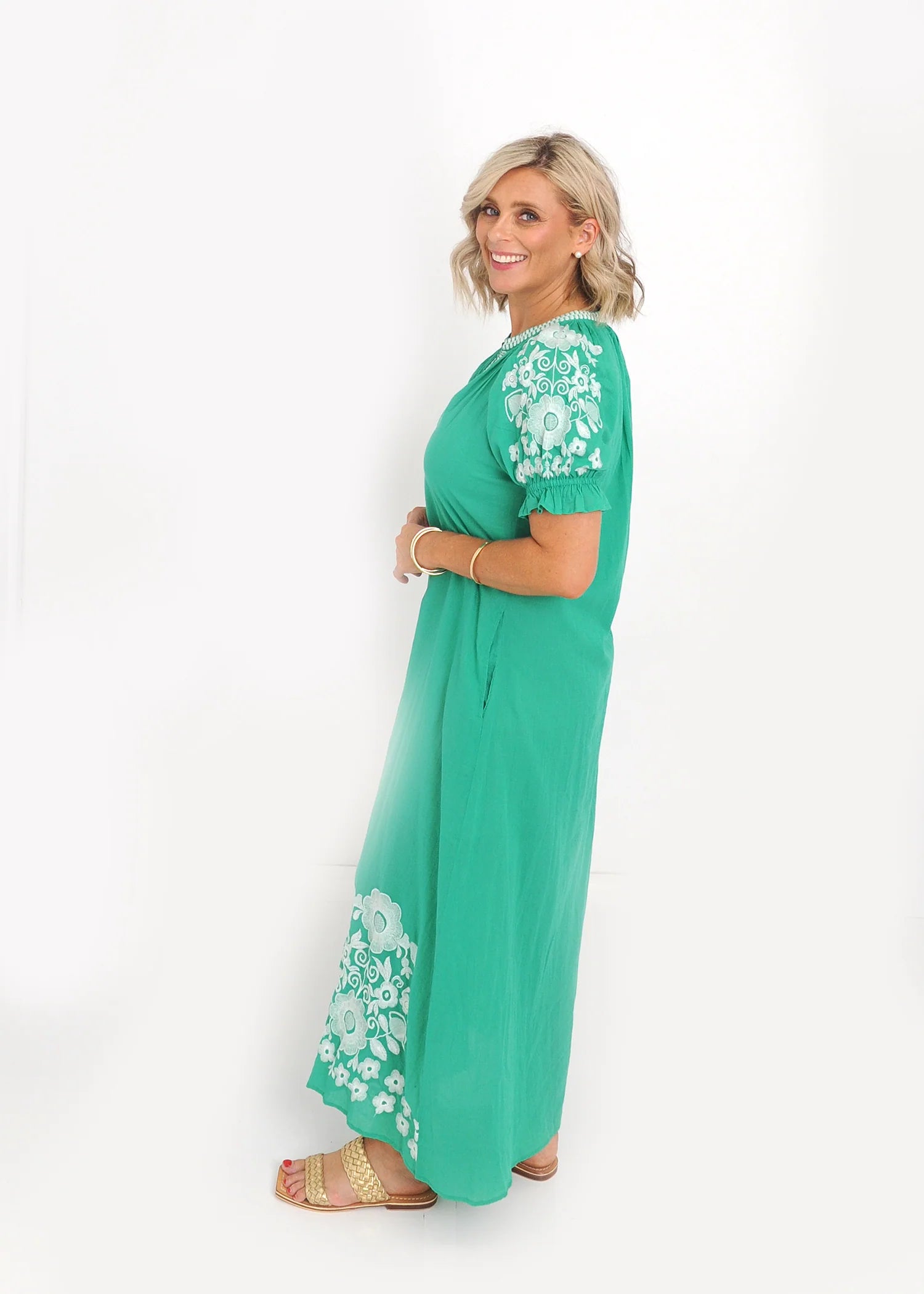 White floral embroidery detail on puff sleeve of green midi dress
