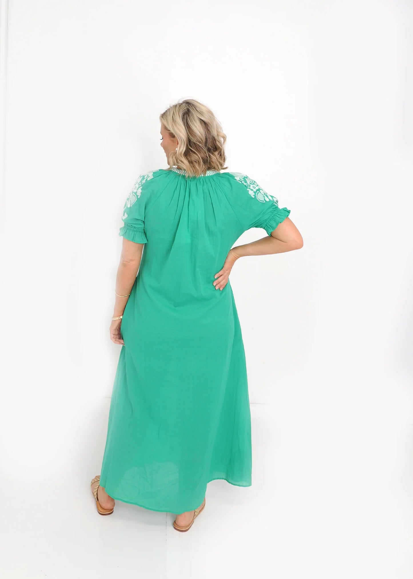 Back view of green cotton midi dress with flowing silhouette