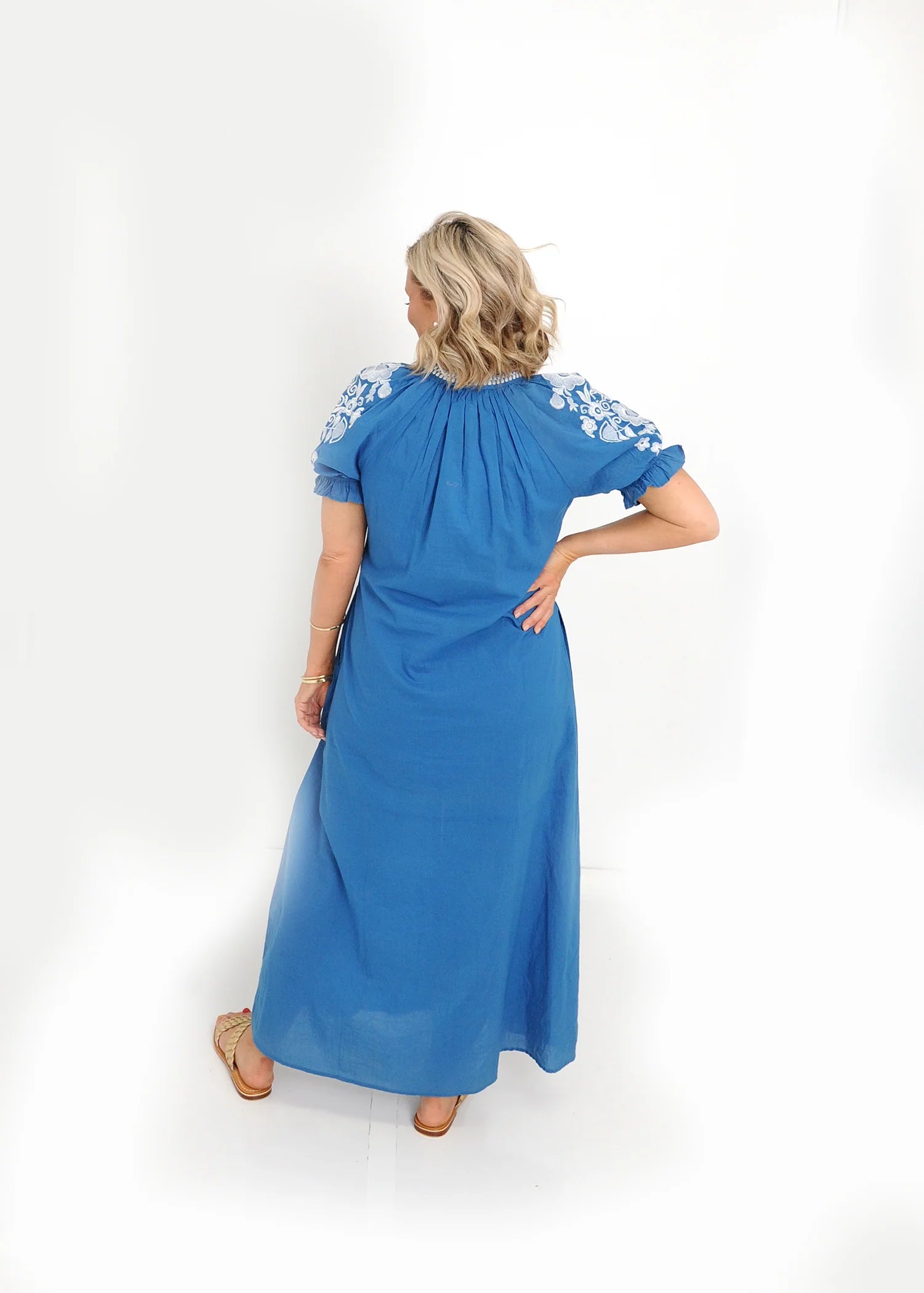 Back view of blue cotton midi dress with flowing silhouette