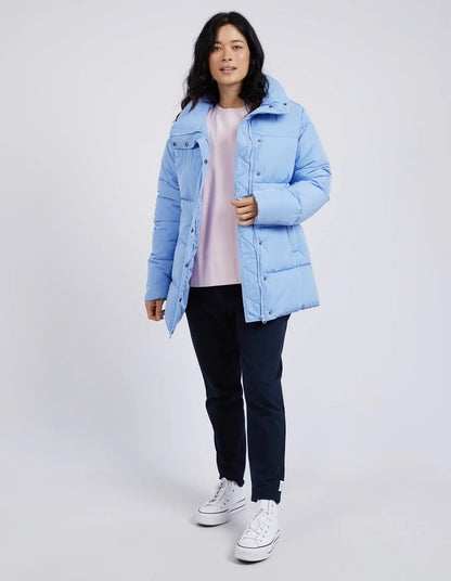 Person wearing a light blue puffer jacket on a white background