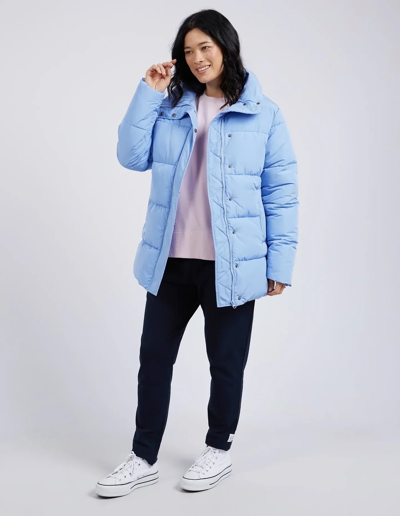 Person wearing a light blue puffer jacket on a white background